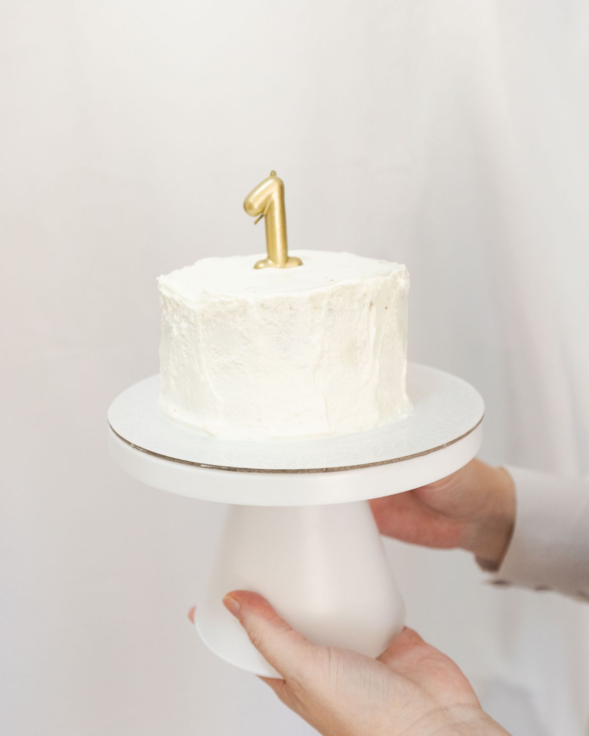 Bela torta sa zlatnom svećicom u obliku broja jedan